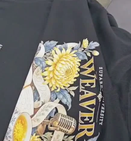 A physical black Sufardi University shirt with a large floral WEAVER print and microphone