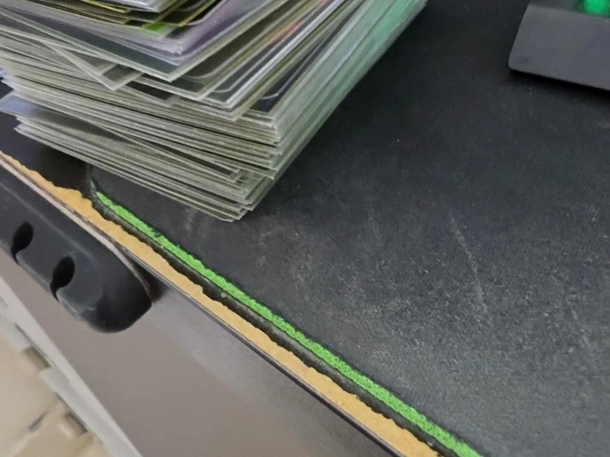 Kapten’s original Pile One: a stack of sleeved cards on a dark desk mat.
